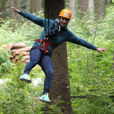 Eine Frau klettert durch den Hochseilgarten
